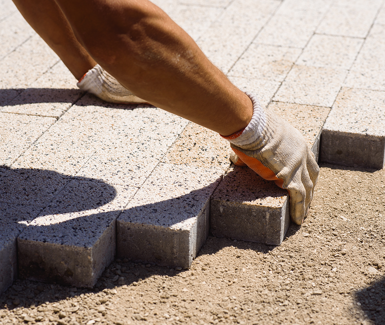 Trabalhador assentando um piso intertravado